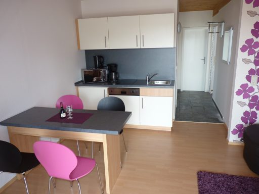 Küchenzeile 1.OG Apartment Wiesenblick Kleine Küchenzeile mit Tisch, Stühlen und modernen Geräten in einem hellen Raum.